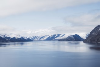 Fascinating view of a wide lake with snow-capped mountains under a blue sky, Wanaka, New Zealand