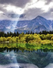 The sun's rays break through the clouds. The lake Fusine in Northern Italy. Mountains covered in