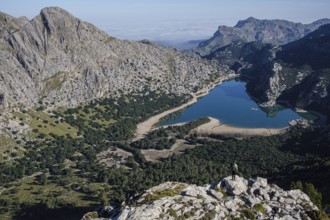 Hiker watching Gorg Blau reservoir, Escorca, Mallorca, Balearic Islands, Spain
