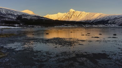 Beautiful winter landscape scene mountain in background in Northern Norway. sunset or sunrise in