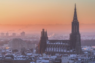 City Ulm in winter with fresh snow and fog. Mountains Alps in background with Minster