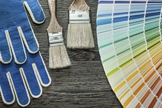 Safety gloves paint brushes pantone fan on wooden board