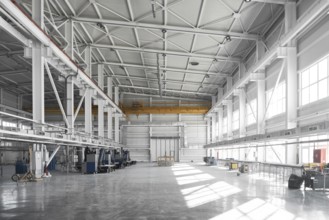Yellow overhead traveling gantry crane beam on the pillars and truss ceilings of industrial