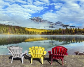 Rocky Mountains of Canada. Three comfortable multi-colored deck chairs stand by the Piramid lake.