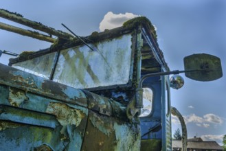 Old car rolled for scrapping in a meadow. Alsace, France