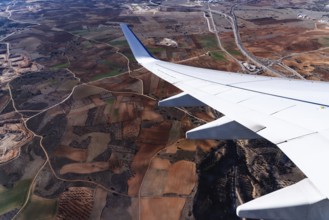 Wing of airplane above fields. Traveling concept