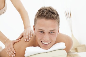 Happy young man enjoying a massage at a health spa