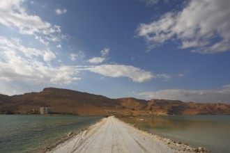 Sunset. Incredible lighting effects in a thunderstorm at the Dead Sea. The road in the middle of