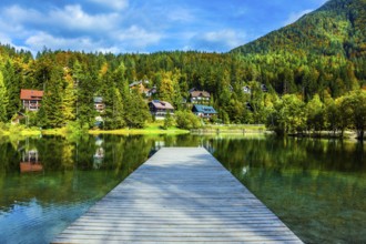 Travel to fabulous Slovenia. Lake Jasna in the Eastern Julian Alps. Wooden pier. The mountains are
