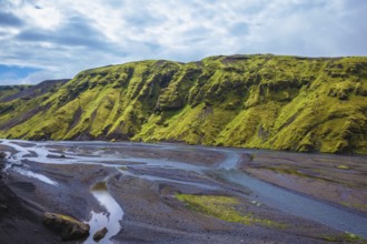 Picturesque basalt hills covered with green grass and moss-polar. At the bottom of the canyon