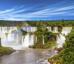 Several waterfalls from Iguazu Falls. Powerful two-stage waterfall creates rainbow and watery dust.