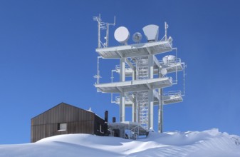 Communication antenna tower and satellite dishes against blue sky