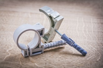 Plastic fixators for pipes On Wooden Board