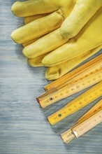 Wooden meter leather safety gloves on wood board construction concept