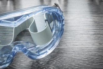 Safety plastic glasses on wooden board