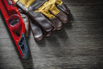 Construction level safety gloves on wooden board