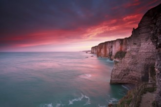 Dramatic sunrise over ocean and cliffs, Etretat, France