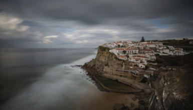 Picturesque village of Azenhas do mar at the top of a rocky hill on the Atlantic Ocean. Long