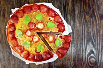 Pie with strawberry, kissel, jelly and mint on a parchment background on wooden board on top