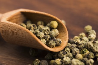 Green Peppercorns on wooden background