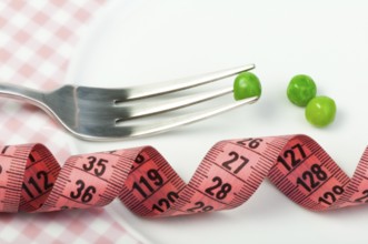 Plate with peas and centimeter measure close up