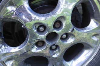 Cracked chrome wheel rim showing rust detail around bolt area