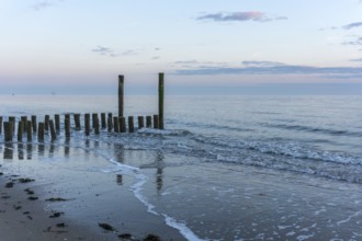Beautiful Sunset at the seaside in the Netherlands with strong colours in the clouds and the water