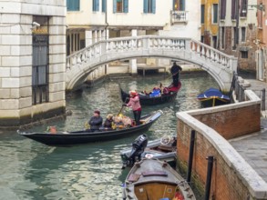 Tourists enjoy a lovely gondola ride on the Rio delle Veste, Venice, Veneto, Italy