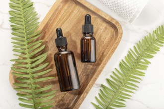 Essential oil bottle on wooden tray. Beauty, skin care, wellness. Yop view