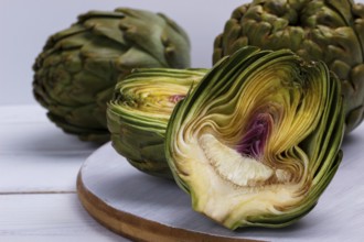 Close up of ripe organic artichokes on rustic wooden board