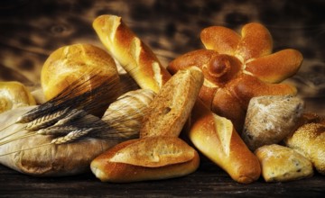 Various types of bread in a rustic setting with warm light