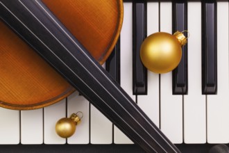 Top view close up shot of piano keyboard, old violin and Christmas decoration. Flat Lay Image
