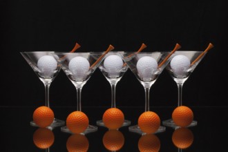 Five glasses of champagne with golf balls