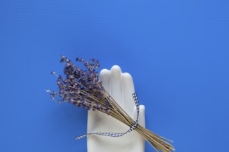 Detail of ceramic hand and bouquet lavender flower on the blue wooden table - Flat Lay Photography