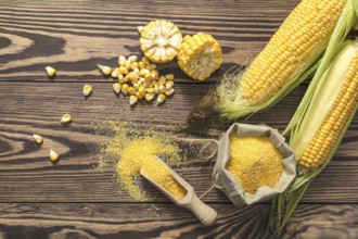 Fresh corn on cobs on rustic wooden table, top view. Dark wooden background freshly harvested