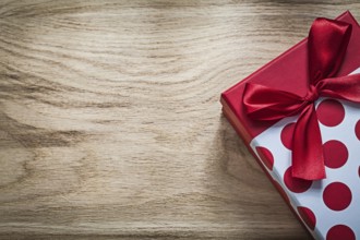 Gift box with red bow on wooden board holidays concept