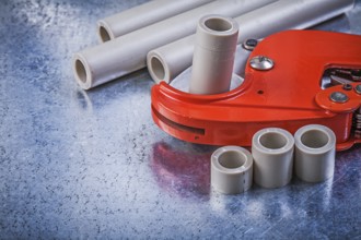 Pvc water pipe cutter on metallic background top view construction concept