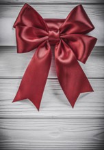 Paper roll with red bow on wooden board holidays concept