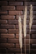 Golden wheat and rye ears on wooden matting