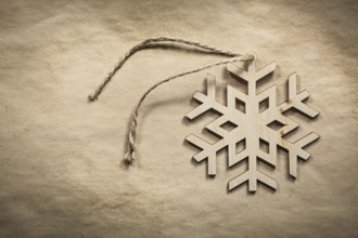 Vintage wooden snowflake string on paper background holidays concept