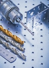 Perforated angle fasteners metal ruler drill and bits on metallic background construction concept