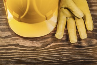Leather safety gloves building helmet on wooden board construction concept