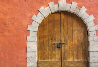 Medieval building entrance with an arched double door, made from hard wood