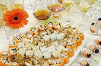 A lot of sushi and drinks on buffet table, catering