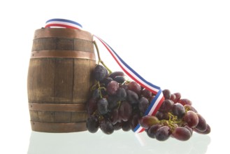 Old wooden wine barrel and buch of red grapes isolated over white background