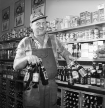 Large selection of beer and lager in 1960. A man with a good grip manages to hold six beer bottles