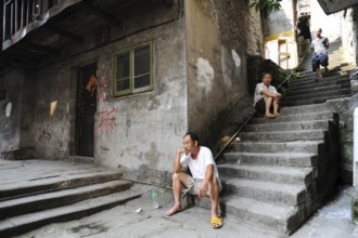 04.08.2012, Chongqing, China, Asia, Men sit on the steps in front of a house in the old town of
