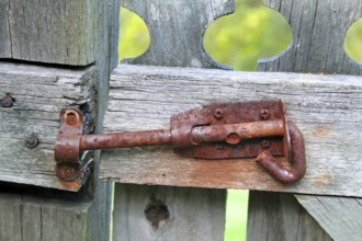 Rusty old latch on an old wooden garden gate