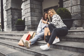 Two young caucasian women having fun on city street outdoors, Best friends enjoying a holiday day