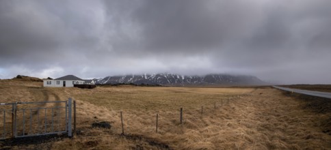 Icelandic landscape at winter. Farmland field, farmhouse stormy cloudy sky Iceland europe